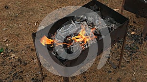 The fire is burning in the grill. Preparation of coals for roasting shish kebab