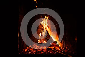 A fire burns in a fireplace, close up shot of burning firewood in the fireplace