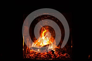 A fire burns in a fireplace, close up shot of burning firewood in the fireplace