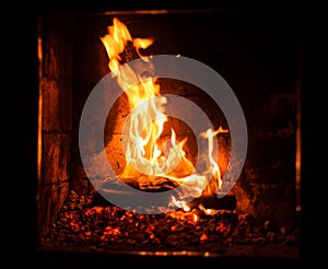 A fire burns in a fireplace, close up shot of burning firewood in the fireplace