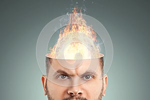 A fire burns in the head of a disgruntled man. The concept of anger, hatred, contempt, stress, burnout, mental illness, irritation