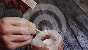 Fire candle scented, close-up of a woman& x27;s hand with a burning match lighting a candle for fire and lighting.