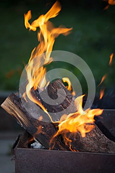 Fire with charcoals. Burning wood. Macro. Live flames with smoke. Wood with flame for barbecue and cooking bbq.