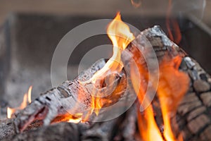 Fire with charcoals. Burning wood. Macro. Live flames with smoke. Wood with flame for barbecue and cooking bbq. Bright color.