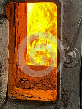 Fire in the combustion chamber of a coal-fired stoker boiler visible through the window