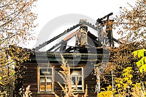 Fire-damaged traditional Russian wooden house izba in autumn. Gorokhovets