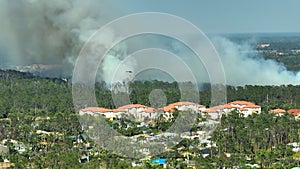 Fire department chopper extinguishing wildfire burning severely in North Port city, Florida. Emergency service