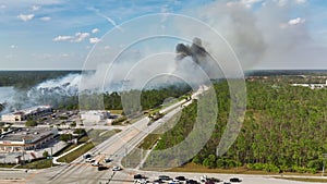 Fire department firetrucks extinguishing wildfire burning severely in Florida jungle woods. Emergency service vehicles