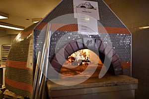 Fire in dome ceramic wood burning pizza oven in the kitchen of A