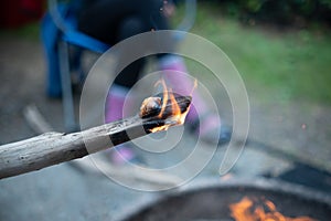 Fire on the edge of a poking stick camping campfire