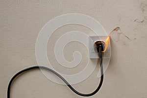 fire electric wire plug Receptacle on the concrete wall background
