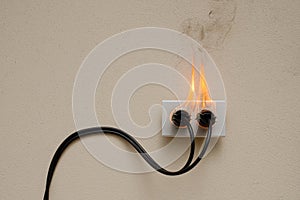 On fire electric wire plug Receptacle on the concrete wall exposed concrete background