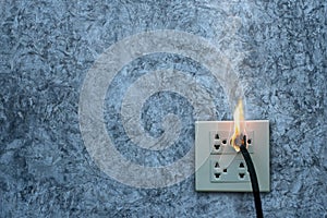 On fire electric wire plug Receptacle on the concrete wall exposed concrete background with copy space