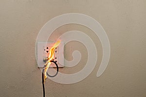 On fire electric wire plug in the receptacle at wall partition