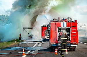 fire engine on the highway extinguishes a burning car after an accident