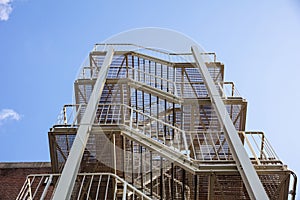 Fire escape. Building external steel staircase against a blue sky