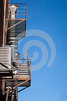 Fire escape rusty stairs and ladder, in metal, on a typical North American old brick building from Montreal, Quebec, Canada