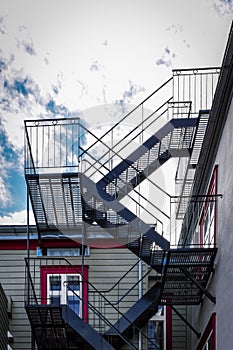 Fire escapes in a building and blue sky with clouds. Real estate and apartment concept. Quebec, Canada