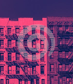 Fire escapes on the exterior of old buildings in New York City in pink and blue color
