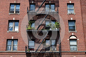 Fire Escapes with Potted Plants on an Old Brick Apartment Building in Astoria Queens New York