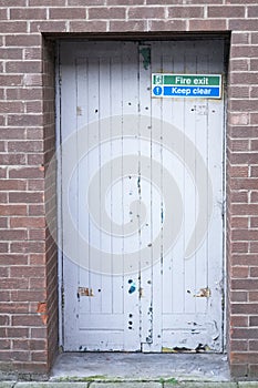 Fire exit keep clear sign on back entrance door at theatre