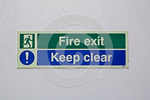 a fire exit keep clear sign on the front of a fire escape door