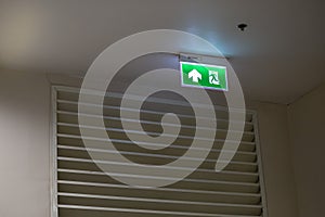 Fire exit sign on the ceiling beside the exit door on the mall