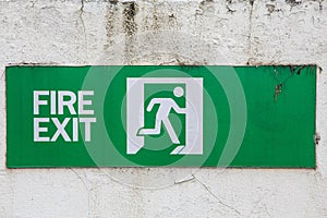 Fire exit sign on old white wall