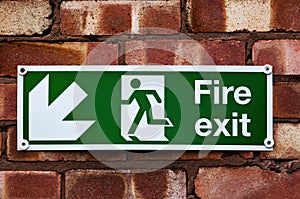Fire exit sign on the red clay brick wall
