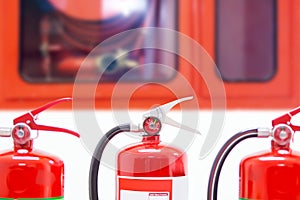 Close-up red fire extinguishers tank with fire hose cabinet at door exit in the building concepts of protection