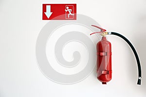 Fire extinguisher and emergency exit sign on wall, space for text