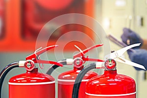 Fire extinguisher with firehose and firefighter checking in the building to prepare equipment for protection and prevent in