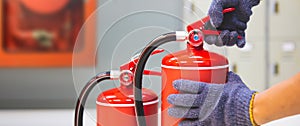 Fire extinguisher has firefighter checking safety pin on handle extinguishers to prepare fire equipment for protection and prevent