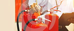 Fire extinguisher has hand engineer inspection checking pressure gauges to prepare fire equipment