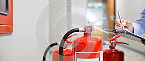 Fire extinguisher has hand engineer inspection checking pressure gauges to prepare fire equipment for protection