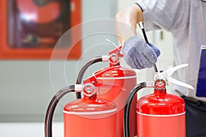 Fire extinguisher has hand engineer inspection checking pressure gauges to prepare fire equipment for protection
