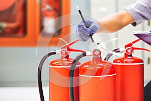 Fire extinguisher has hand engineer inspection checking pressure gauges to prepare fire equipment for protection and prevent in