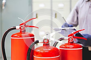 Fire extinguisher has hand engineer inspection checking pressure gauges to prepare fire equipment for protection and prevent in
