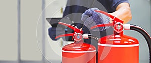 Fire extinguisher has hand engineer inspection checking pressure gauges to prepare fire equipment for protection and prevent in