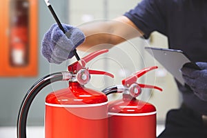 Fire extinguisher has hand engineer inspection checking pressure gauges to prepare fire equipment for protection and prevent in