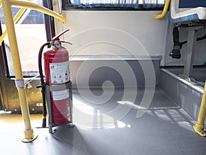 Fire extinguisher secured in bracket on bus.