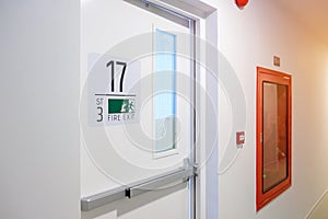 Fire extinguisher system on the wall with Fire Exit door sign for emergency. Stairwell fire for escape in building or apartment