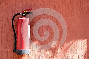 Fire extinguisher on the terracotta exterior wall of the house