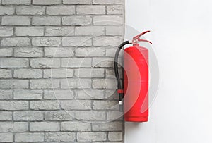 Fire extinguisher on white brick wall background. photo