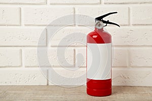 Fire extinguisher on white brick wall with clipping path