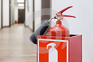 Fire extinguisher in white corridor of business center