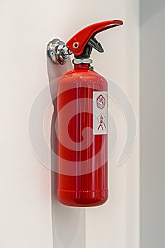fire extinguisher on white wall, close up