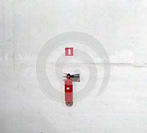 Fire extinguisher on white wall, ready for use