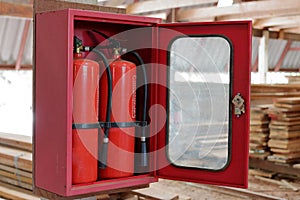 Fire extinguishers on blurry stack of wood in warehouse