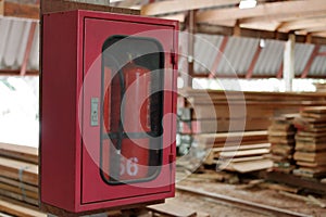 Fire extinguishers on blurry stack of wood in warehouse